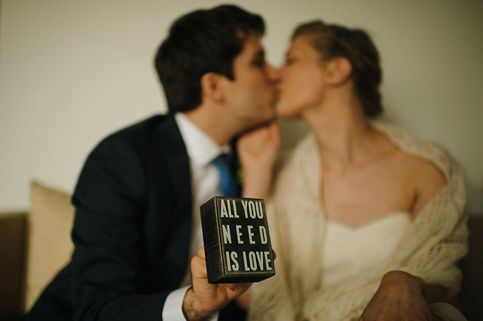 groom holding all you need is love sign