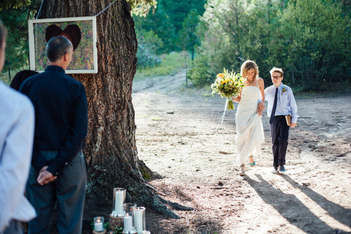 bride walking down aisle with son