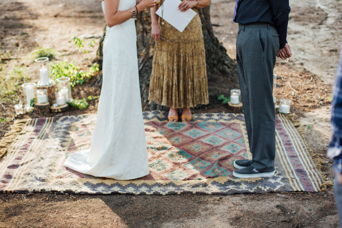 bride and groom standing on rug in outdoor ceremony