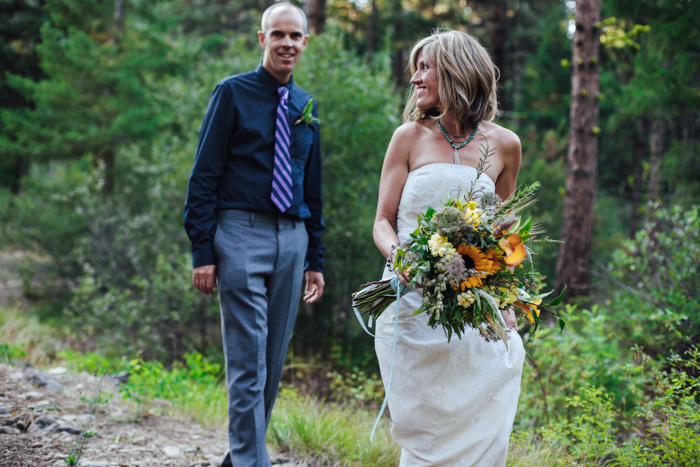 bride and groom walking in the woods