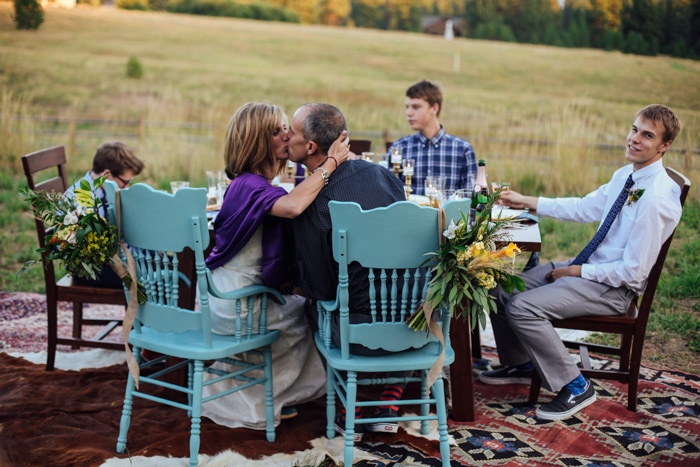 bride and groom kissing at table