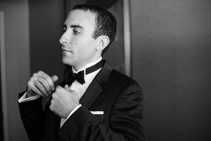 groom adjusting bow tie