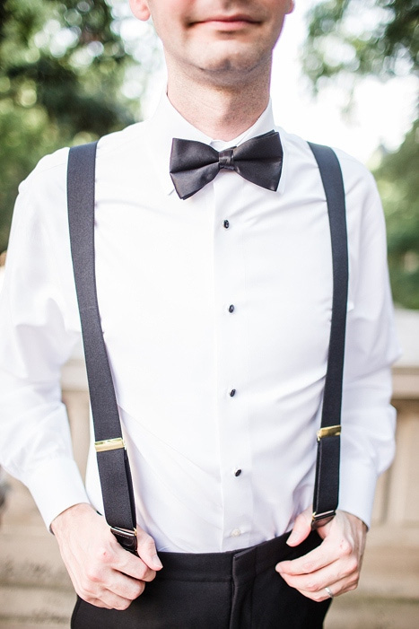 groom in suspenders and black bow tie