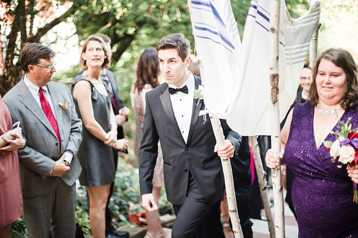 bridal party carrying the chuppah