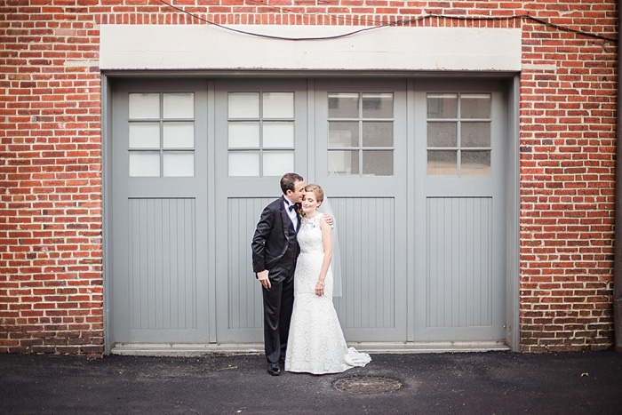 bride and groom in front of grey garage doors