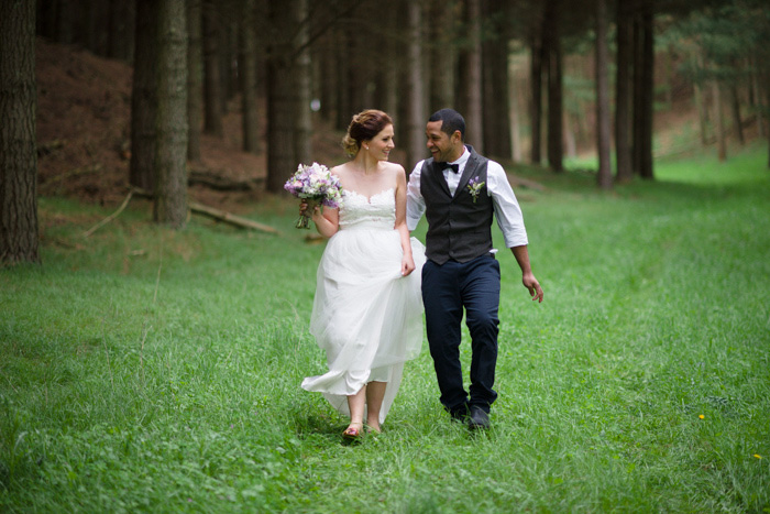 bride and groom walking in the woods