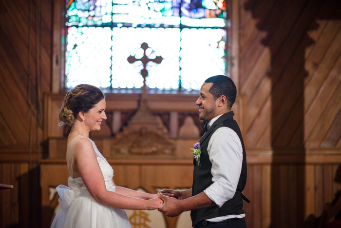 bride and groom holding hands at altar