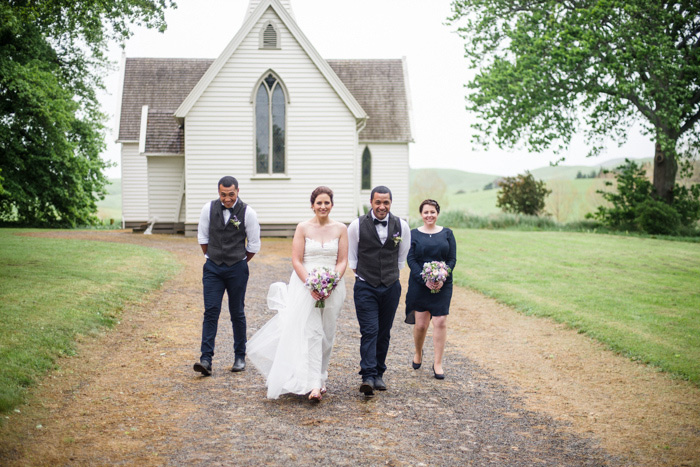 bridal party walking away from  chapel