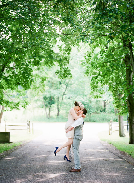 groom lifting bride as he kisses her