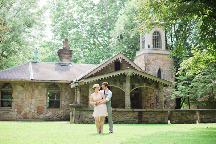 bride and groom in front of stone cottage