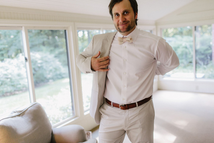 groom putting on jacket