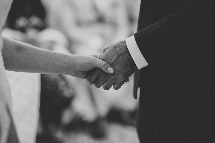 bride and groom holding hands during ceremony