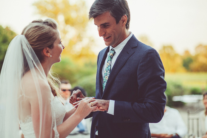 bride putting ring on groom's finger