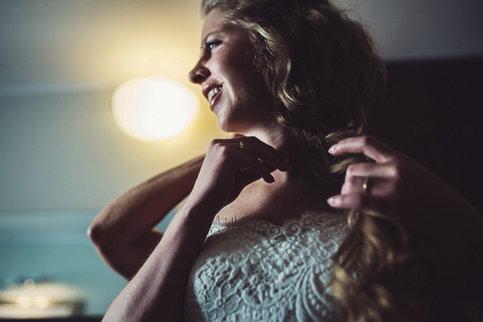 bride putting on her necklace