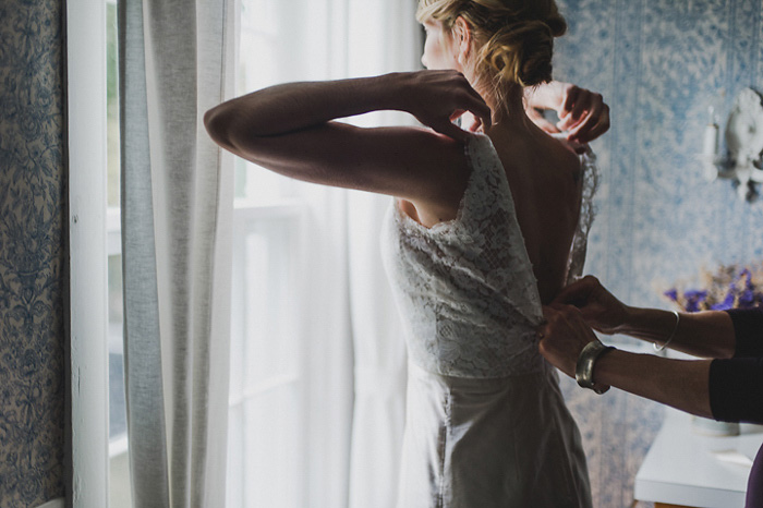 bride getting her dress zipped up