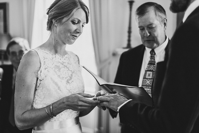 bride putting ring on groom's finger