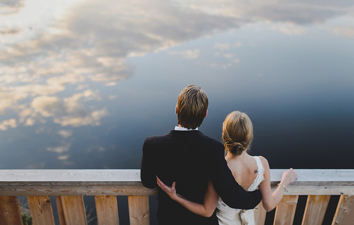 bride and groom looking out on the lake