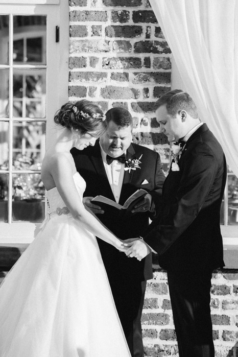 bride and groom with heads bowed at wedding ceremony