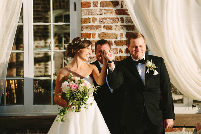 bride and groom facing guests at wedding ceremony