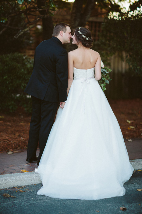 bride and groom kissing on street