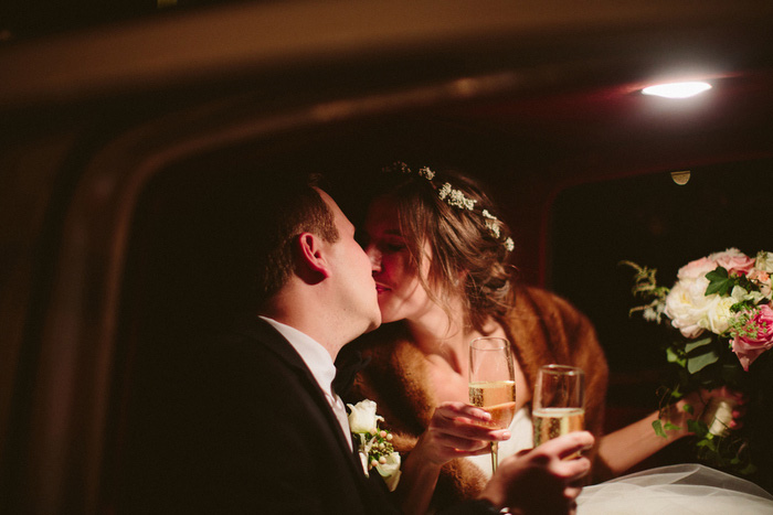 bride and groom kissing in car