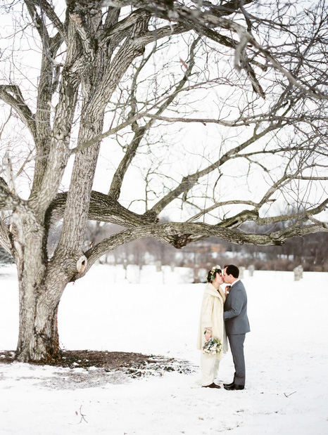 bride and groom kissing in the snow