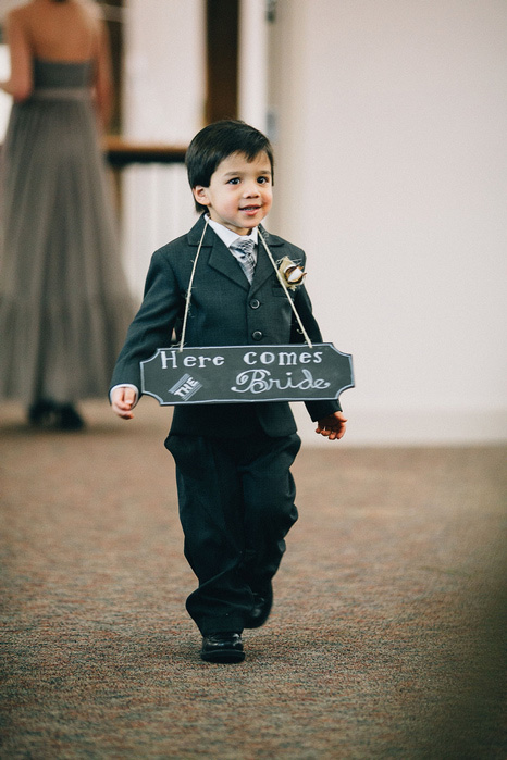 ring bearer wearing here comes the bride sign