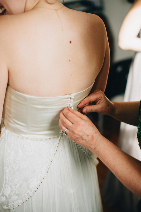 bride having dress buttoned up