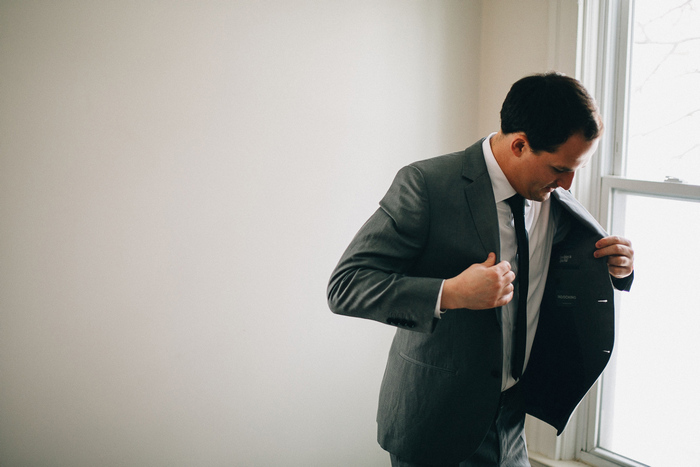 groom putting on jacket