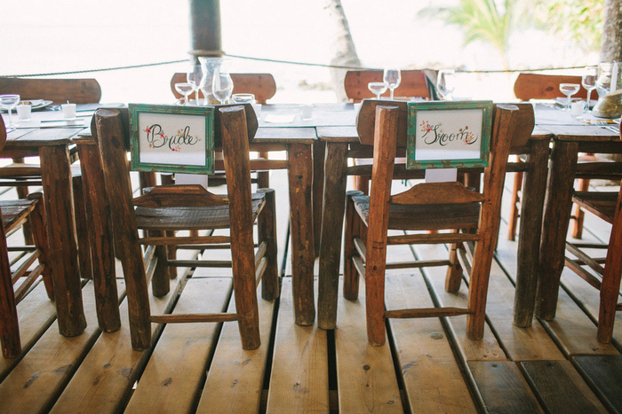 bride and groom signs on backs of chairs