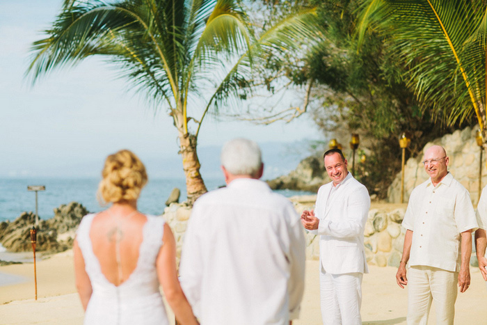 groom watching his bride walking down the aisle