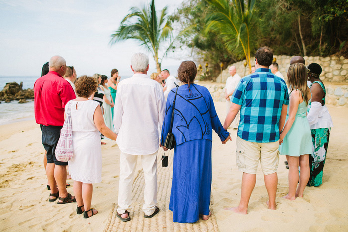 wedding guests holding hands during ceremony