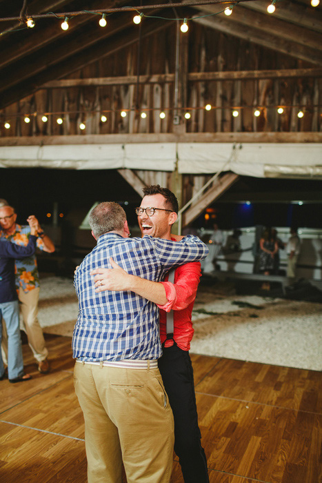 groom hugging guest on dance floor