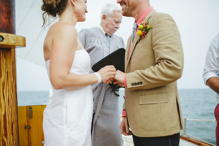 bride putting ring on groom's finger