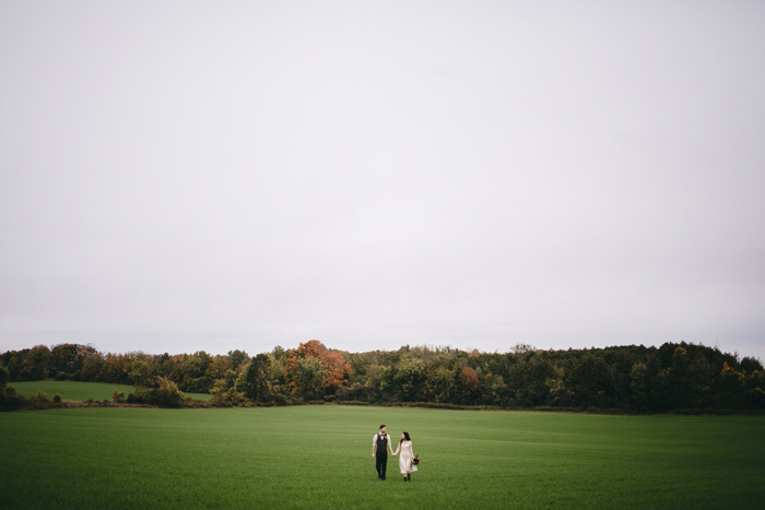 bride and groom walking across field