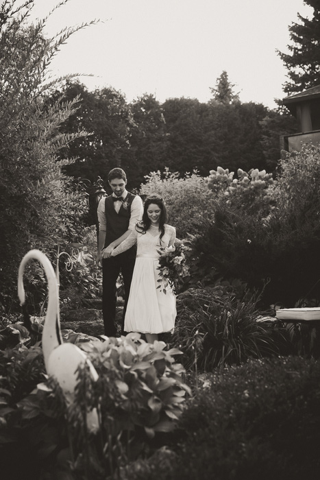 bride and groom walking through garden