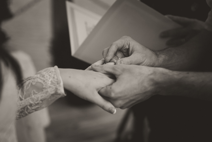 groom putting ring on bride's finger