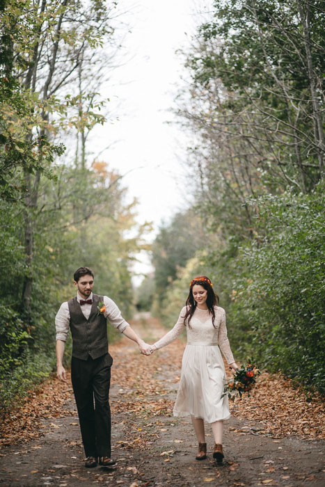 bride and groom walking in the woods