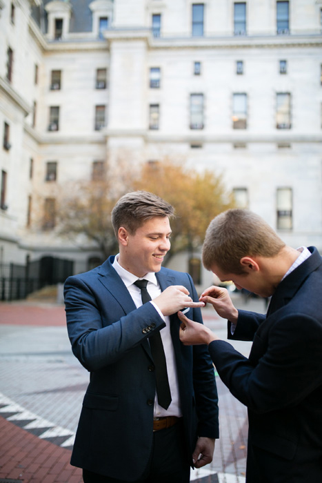 groom pinning on his boutonniere