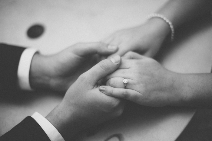 close-up of bride and groom holding hands