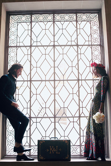 Bride and groom standing inside City Hall window