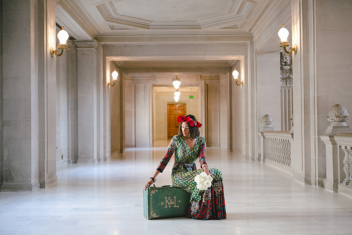 bride sitting on vintage suitcase