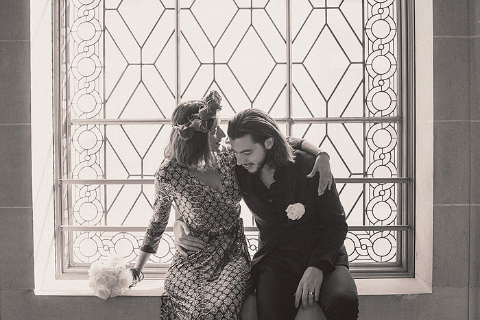 brie and groom sitting on window ledge