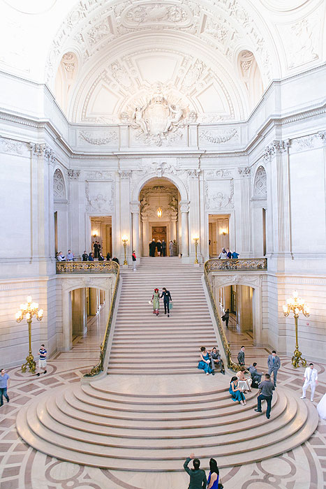 bride and groom walking down city hall stairs