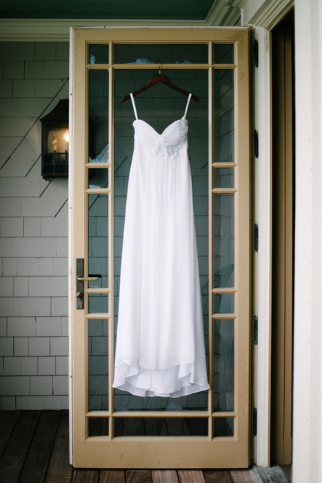 wedding dress hanging on door