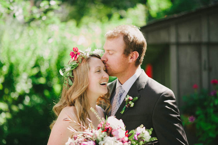 groom kissing bride's forehead