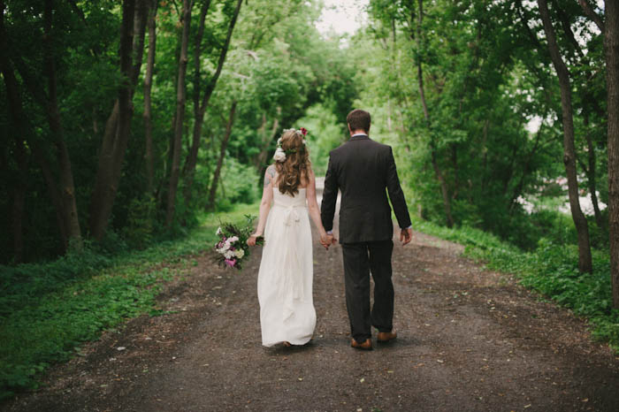 bride and groom walking down dirt road