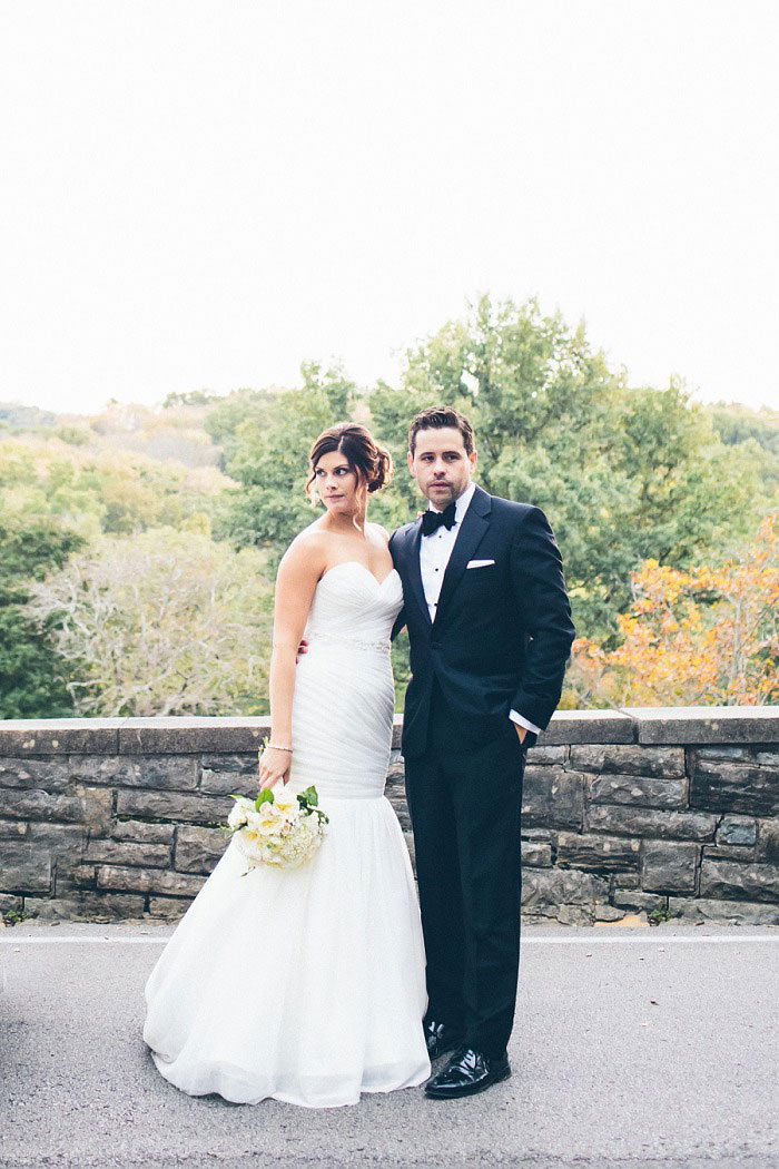 bride and groom portrait in front of stone wall