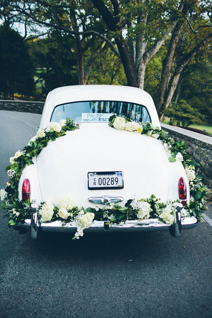 vintage wedding car with floral garland