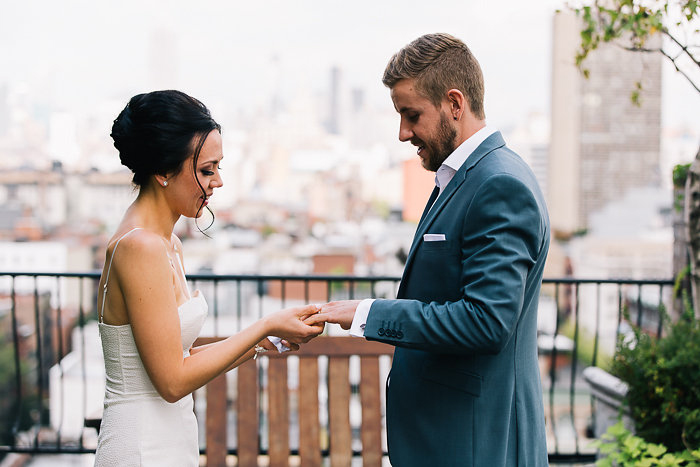 bride placing ring on groom's finger